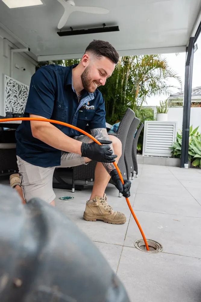 High pressure water jetter hose being fed into a drain